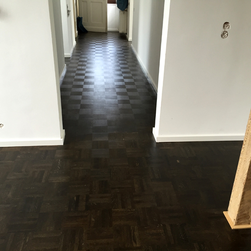 Ein gefärbter Holzboden setzt farbliche Akzente im Raum.