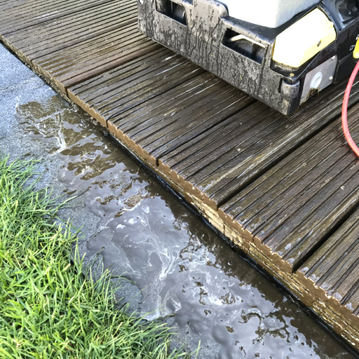 Schmutz löst sich aus den Terrassendielen während der Reinigung