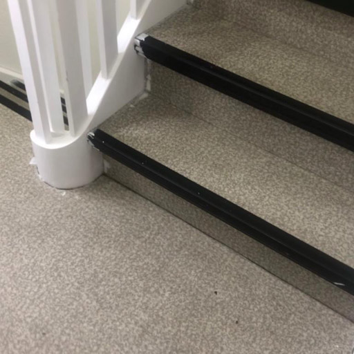 Treppe vor der Treppenrenovierung / Teppensanierung: Belag mit grauem PVC/Vinyl