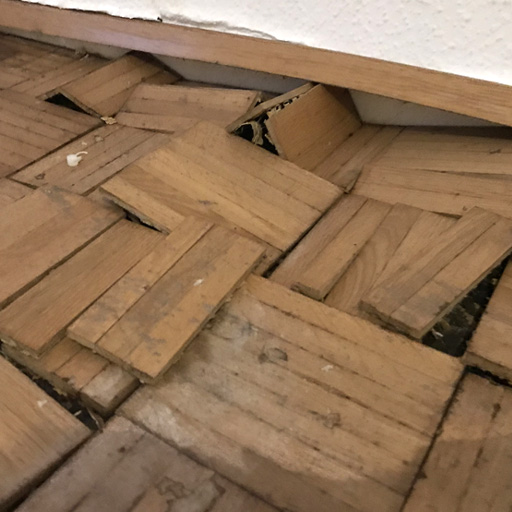 Typisches Bild eines Wasserschadens im Parkett durch Rohrbruch