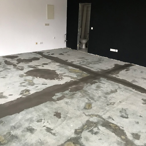 Fugen und große Unebenheiten werden mit Spachtelmasse gefüllt, bevor der Sichtestrich als Bodenbelag fertig ist.