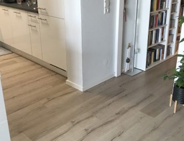 Laminat in einem Raum mit Küche und Flur. Artikel: Laminat durchgehend verlegen von Raum zu Raum – geht das?: