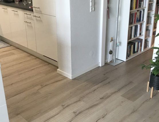 Laminat in einem Raum mit Küche und Flur. Artikel: Laminat durchgehend verlegen von Raum zu Raum – geht das?:
