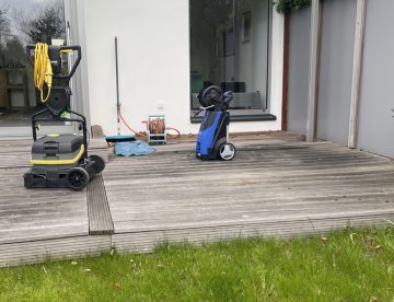 Holzterrasse putzen und streichen: Eine vergraute Holzterrasse mit einer Maschine zur Reinigung