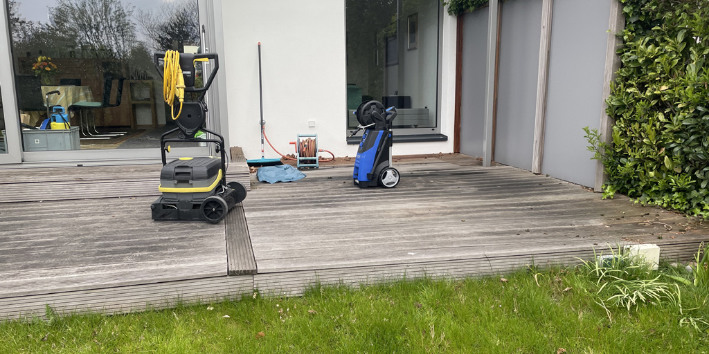 Holzterrasse putzen und streichen: Eine vergraute Holzterrasse mit einer Maschine zur Reinigung